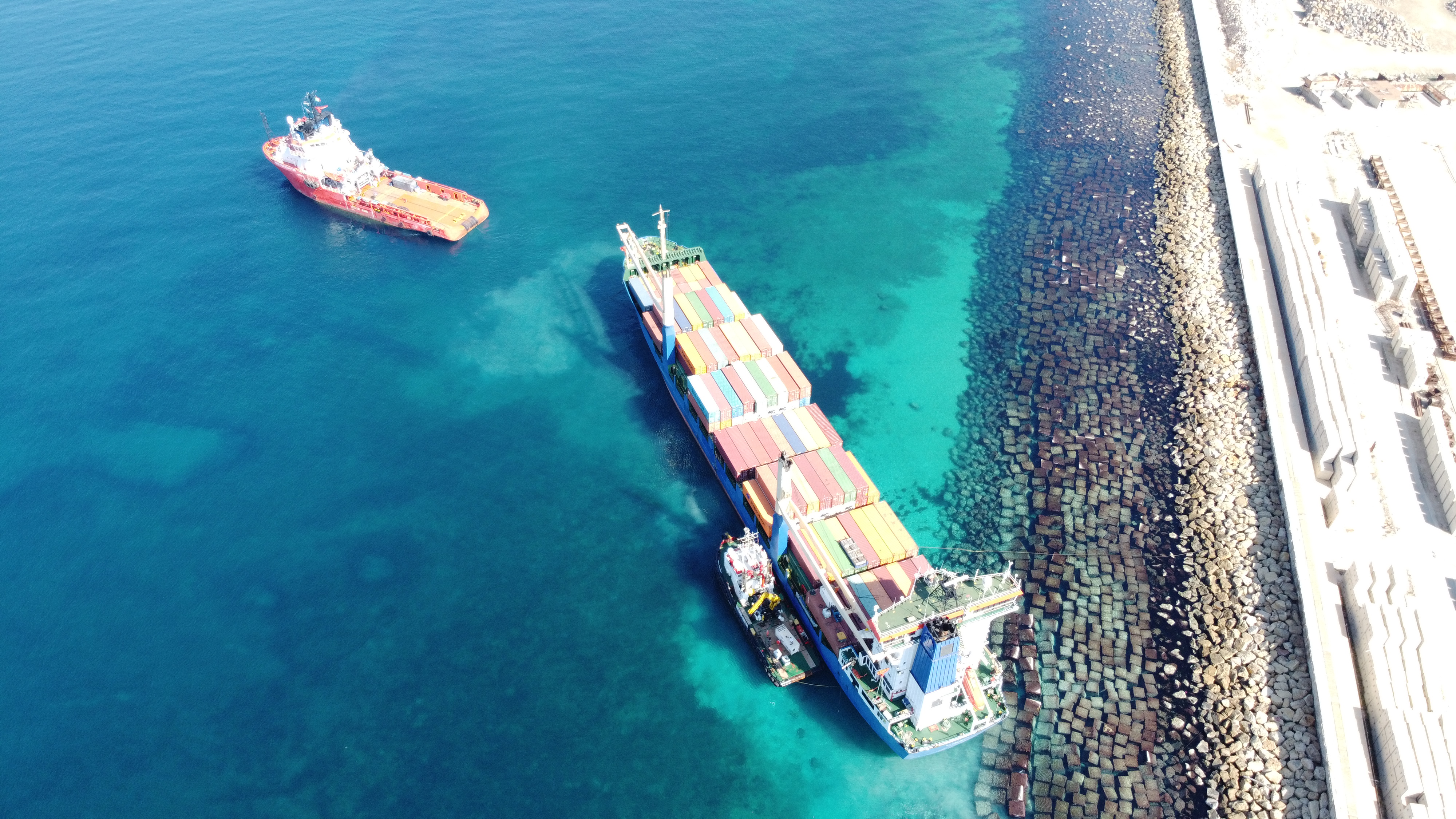 Rescue boat pilots away from vessel full of shipping containers